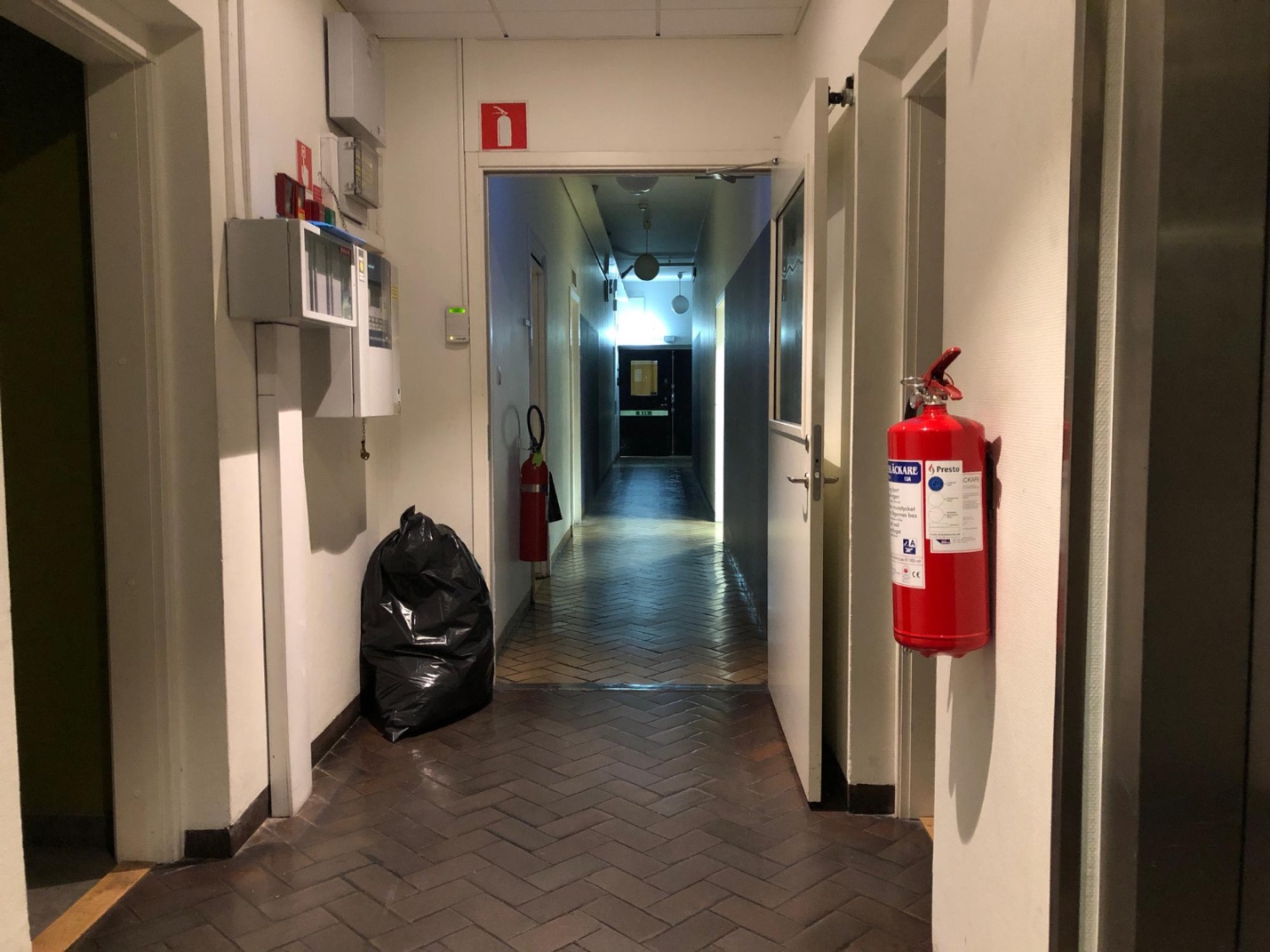 A hallway with fire extinguisher and a fire extinguisher

Description automatically generated