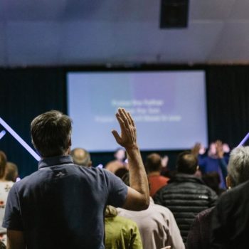 shallow focus photo of person raising right hand