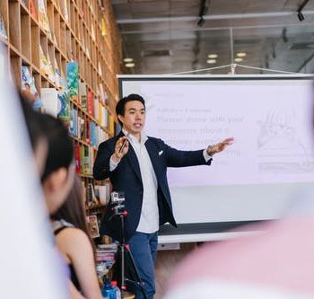 Man in suit jacket standing beside projector scree best financing methods for your business