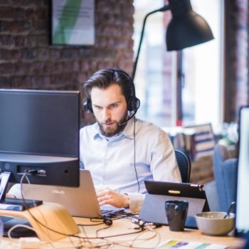 man wearing headphones in front of computer