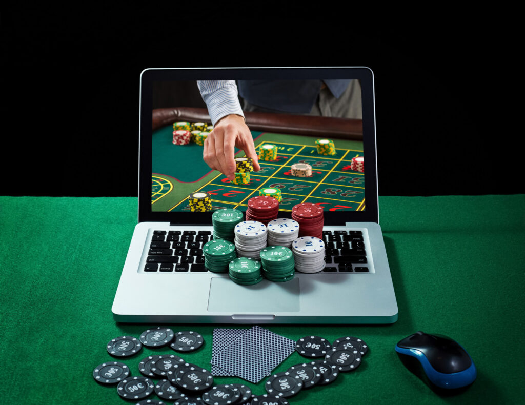 Green Table with Casino Chips and Cards on Notebook online gambling 101 is it legal to gamble online