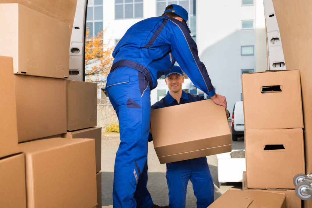 Movers Carrying Sofa Outside Truck on Street three services offered by long distance moving companies