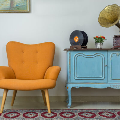 Vintage Interior of Retro Orange Armchair Vintage Wooden Light Blue Sideboard Old Phonograph gramophone Vinyl Records on Background of Beige Wall Tiled Porcelain Floor and Red Carpet how to choose the best furniture style for your home