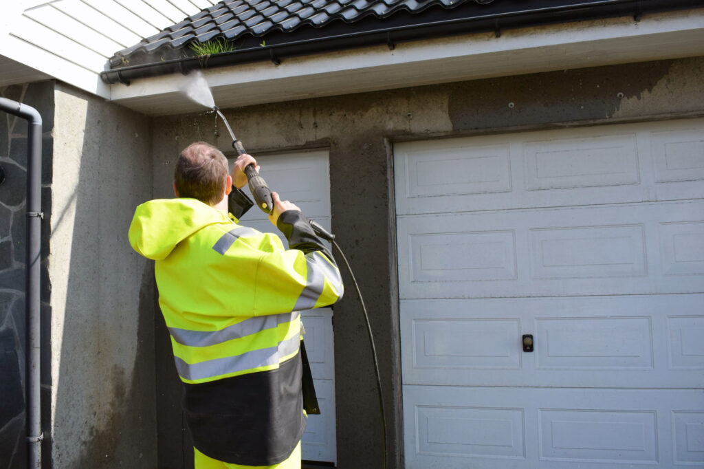 the Man Cleans the Walls from the Side of the Street with the Help of a Stream of Water Under Pressure the perks of pressure washing the exterior of your home