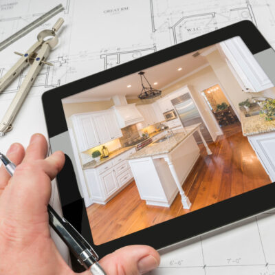 Hand of Architect on Computer Tablet Showing Custom Kitchen Photo over House Plans Compass and Ruler 5 kitchen renovation ideas for you to consider